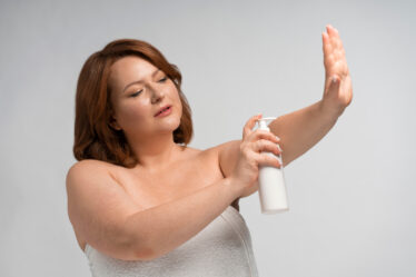 Mulher usando body splash após o banho